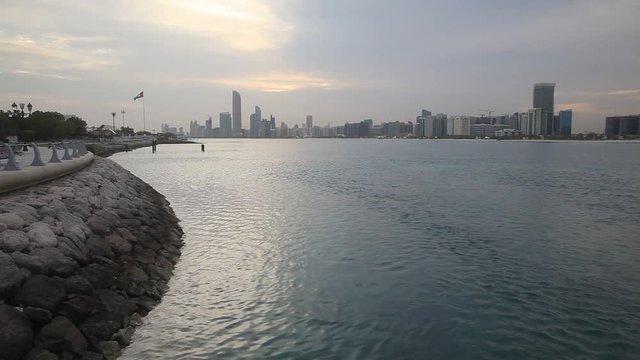 Abu Dhabi skyline with clouds at the sunrise. Establishing shot.