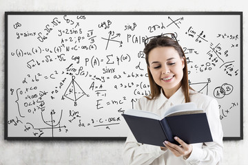 Formulas on whiteboard and woman with book