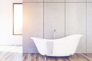 Fototapeta na wymiar Concrete bathroom, white tub, toned