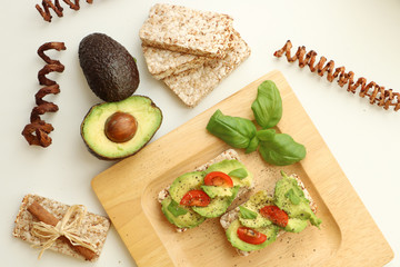 Snack of avacodo with basil on the wooden plate