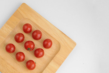 Nine cherry tomatoes on the wooden plate