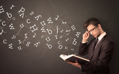 Young man holding book with letters