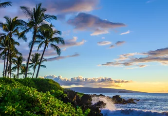 Photo sur Plexiglas Plage tropicale Belle plage tropicale au coucher du soleil. Palmiers et feuillage local luxuriant. L& 39 eau éclabousse sur les roches de lave. Lieu de destination touristique à Maui, Hawaï