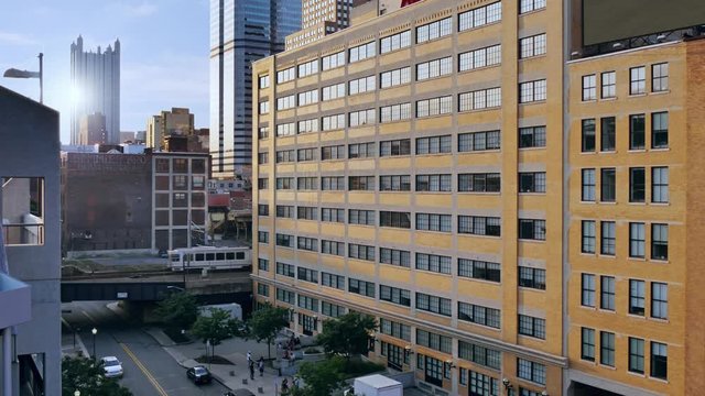 A dusk establishing shot of a downtown Pittsburgh apartment or office building as a subway train passes by.	
