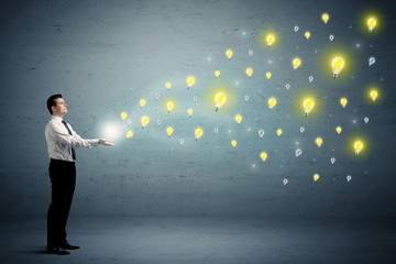 Fototapeta premium Businessman holding lightbulbs