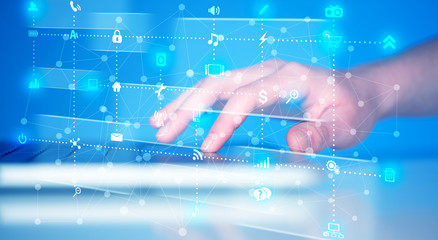 Hand pressing keyboard with high tech media icons