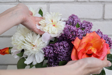 Woman holding spring flowers bouquet : peony, rose, lilac