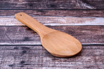 Wooden spoon on wooden background.