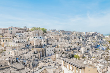 Fototapeta na wymiar panoramic view of typical stones (Sassi di Matera) near gravina of Matera UNESCO European Capital of Culture 2019 on blue sky
