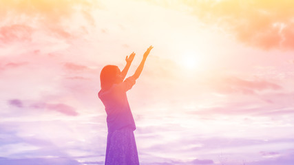Silhouette of woman praying over beautiful sky background - obrazy, fototapety, plakaty
