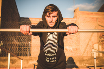Chico joven mirando al horizonte al atardecer en la azotea