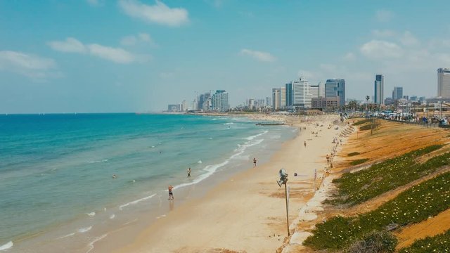 WIDE Handheld daytime shot of calm sea, waves splashing over the sandy shore near Tel Aviv, Israel. 4K color graded footage