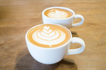 Cup of latte art coffee on wooden table