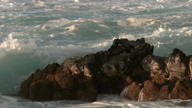 Waves crashing on the shore rocks in slow motion