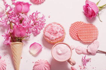 Flowers in a waffle cone with yogurt and meringues on white background