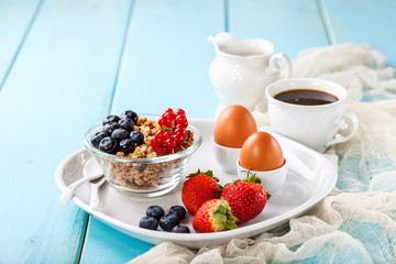 Breakfast - muesli, berries and coffee. Selective focus. Copy space