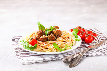 Spaghetti with meat balls in a plate on a table. Selective focus. Copy space