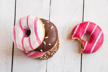 Colorful donuts on white wooden table