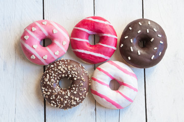 Colorful donuts on white wooden table