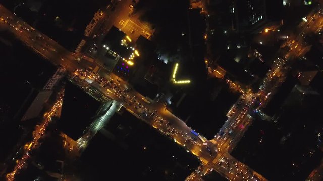 Center of Vladivostok Russia. Old and modern buildings roofs. Night illumination cars city traffic. High Aerial drone flight above.