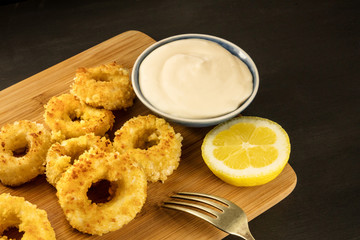 Closeup of calamari rings with aioli sauce and copyspace