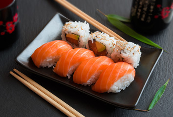 Salmon sushi and roll sushi on black