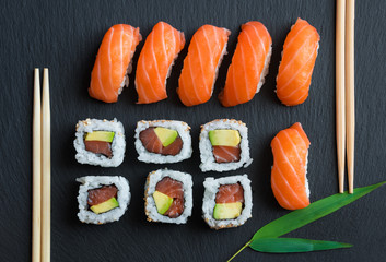 Salmon sushi and roll sushi on black