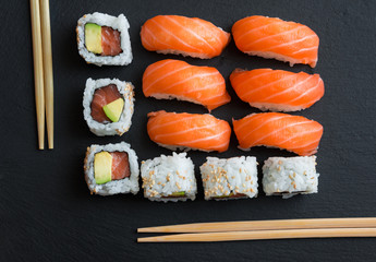 Salmon sushi and roll sushi on black