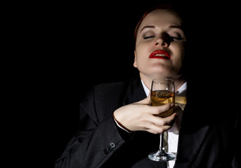 crazy woman in a man's suit drinks champagne, wildly laughs