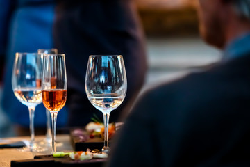 Silhouettes of people sitting at a table in the restaurant. On the table plates glasses.
