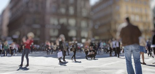 Crowd of anonymous people walking on busy city street