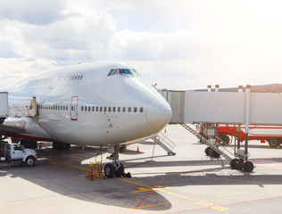 large passenger plane parked at airport ready to fly. The tanker, the tunnel on the background of sunlight