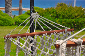 Fototapeta premium empty hammock in a green bright garden overlooking the sea