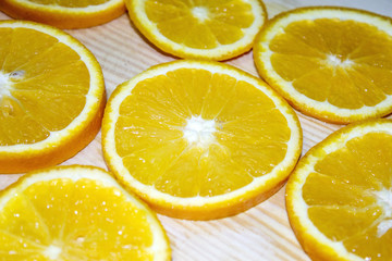 bright, rich orange wedges lying on a wooden table. There is a place for text.