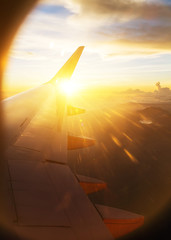View of the sunset,clouds and airplane wing from the Inside