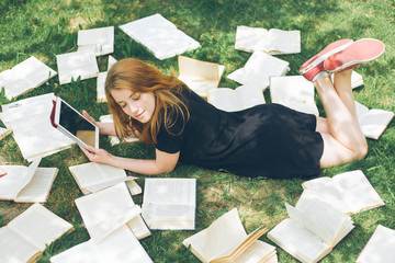 Woman learning with ebook reader and book. Choice between modern educational technology and traditional way method. Girl holding digital tablet pc and textbook. Contemporary education.