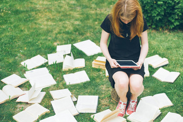 Woman learning with ebook reader and book. Choice between modern educational technology and traditional way method. Girl holding digital tablet pc and textbook. Contemporary education.