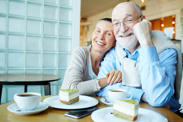 Fototapeta na wymiar Affectionate seniors sitting in cafe