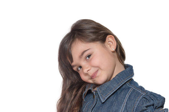 Portrait of simper brunette long haired little girl isolated on the white background. The little girl is looking at a camera with a bowed head