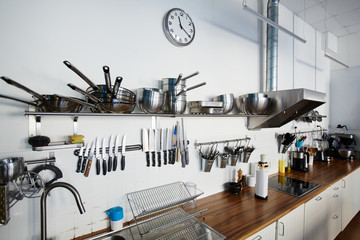 Various types of metallic kitchenware and workplace of chef