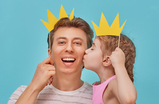 Dad and child are holding paper crown
