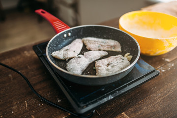 Frying pan with fish slices, seafood cooking