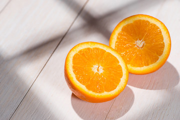 Half of orange on white wooden table.