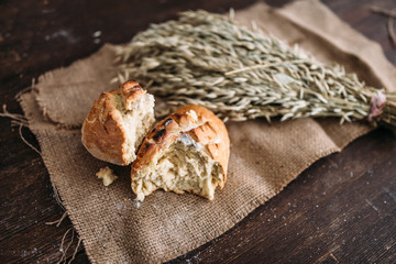 Bread loaf breaked in half, wheat on burlap cloth