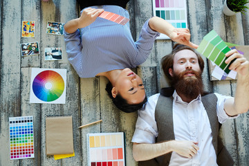 Directly above view of creative designers team , Asian woman and bearded man, working in modern...