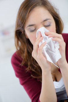 Pretty Woman Sneezing On Couch At Home In Living Room