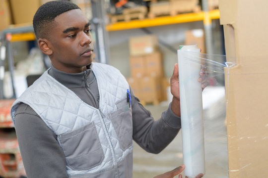 Young Worker Shrink Wrapping Pallet