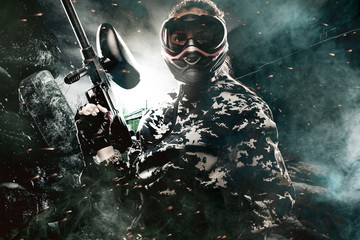 Heavily armed masked paintball soldier on post apocalyptic background. Ad concept.