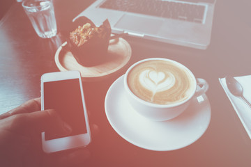 cup of coffee on old wooden desk. Simple workspace or coffee break in morning/ selective focus