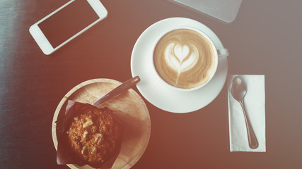 cup of coffee on old wooden desk. Simple workspace or coffee break in morning/ selective focus